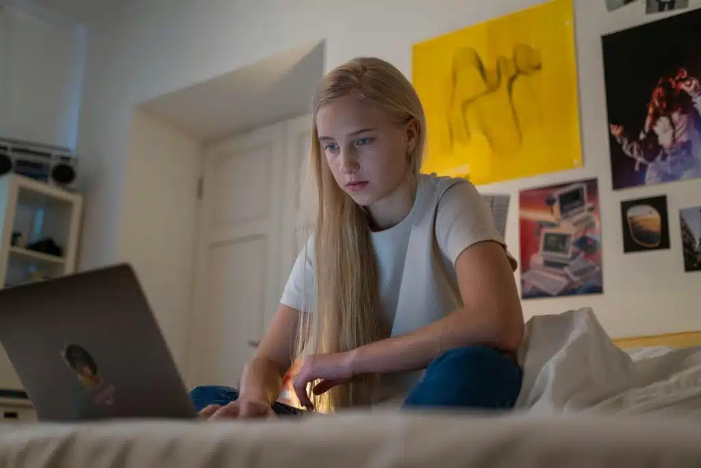 Person working on laptop in bed.