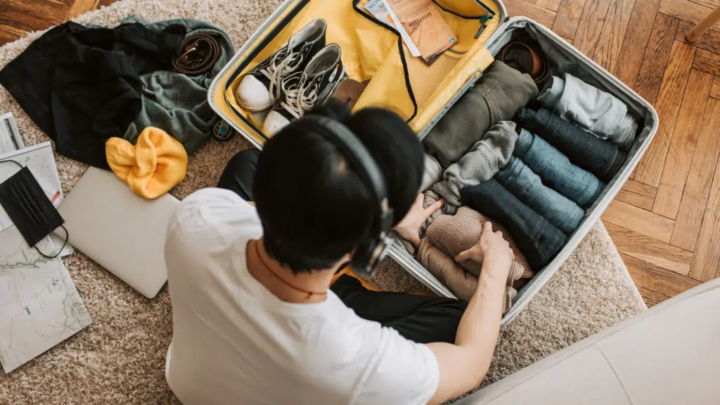 Young man packs his case as he's navigating life in two homes